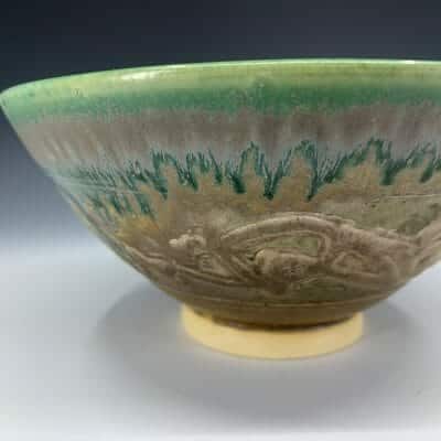 Green glossy drips turn into blues as they flow onto the matte brown on this traditional bowl.